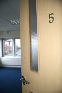 Open door leading in to unfurnished office.